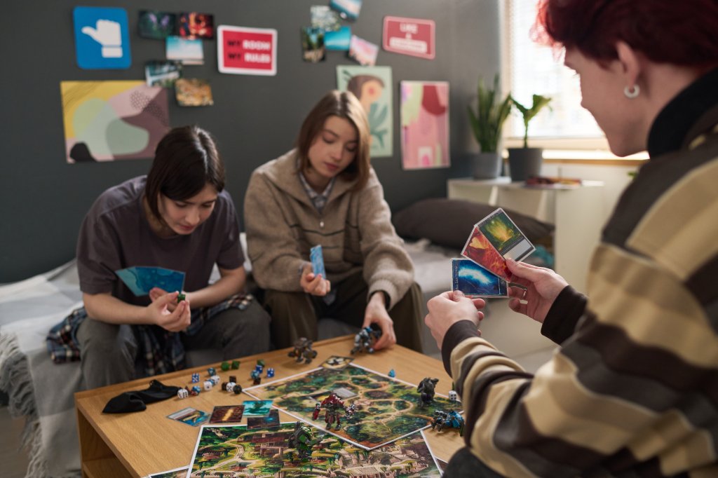 3 teenagers are playing Dungeons and Dragons in a bedroom.