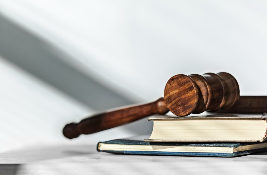 A judge's hammer is sitting. on a stack of books.